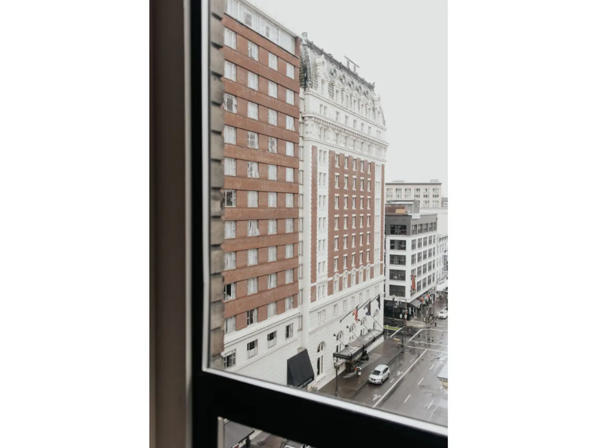 A reflective, rain-soaked city street with beautiful historical architecture and an urban landscape. The calm ambiance suggests a peaceful moment after exploring the city, with the allure of local shops and cozy indoor spaces.